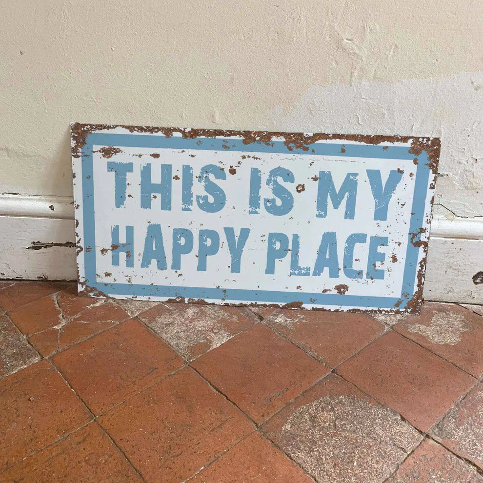 Vintage-style sign with 'This is my happy place' text on a tiled floor.
